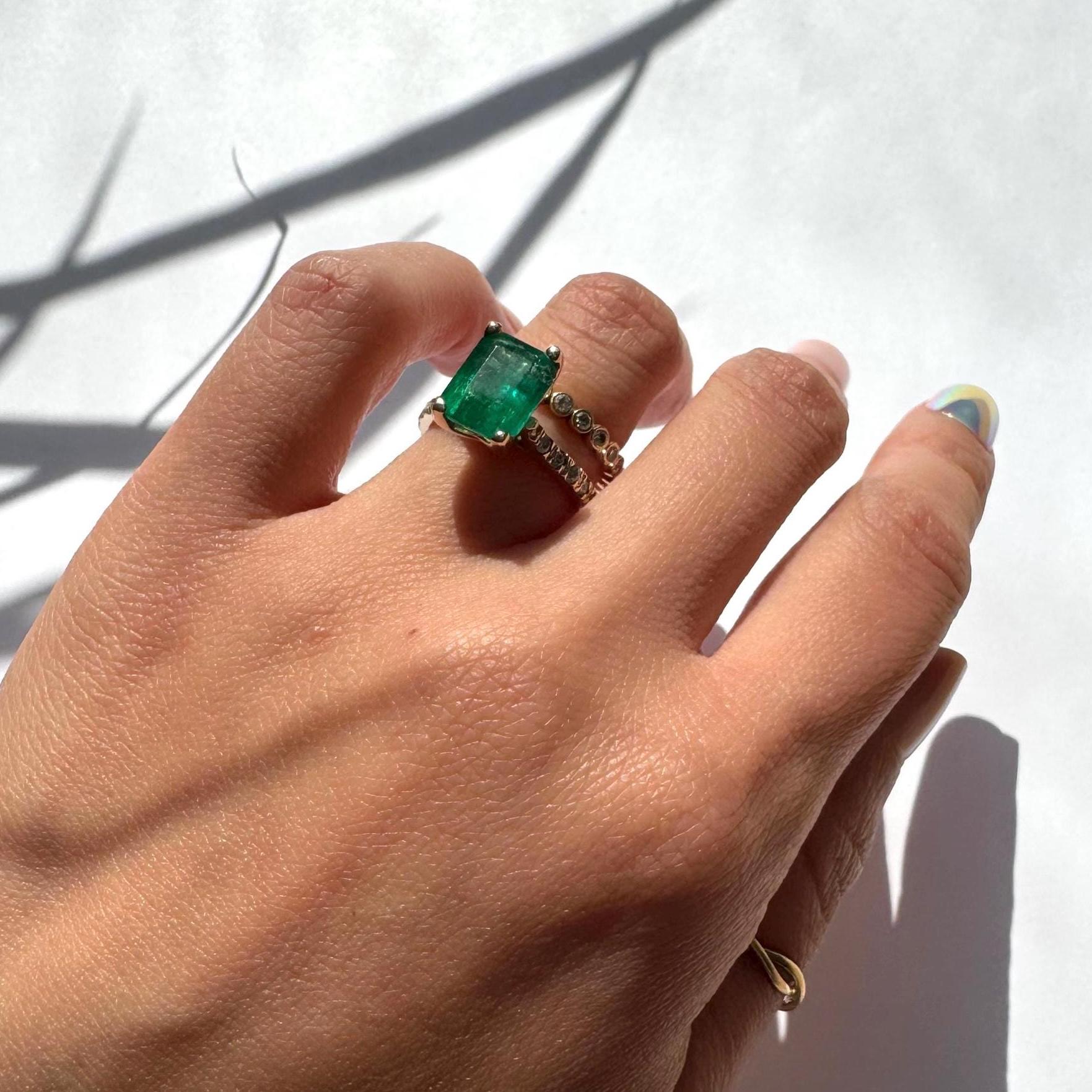 a girl wearing 14k yellow gold ring with authentic natural emerald and natural diamonds engagement ring anniversary ring