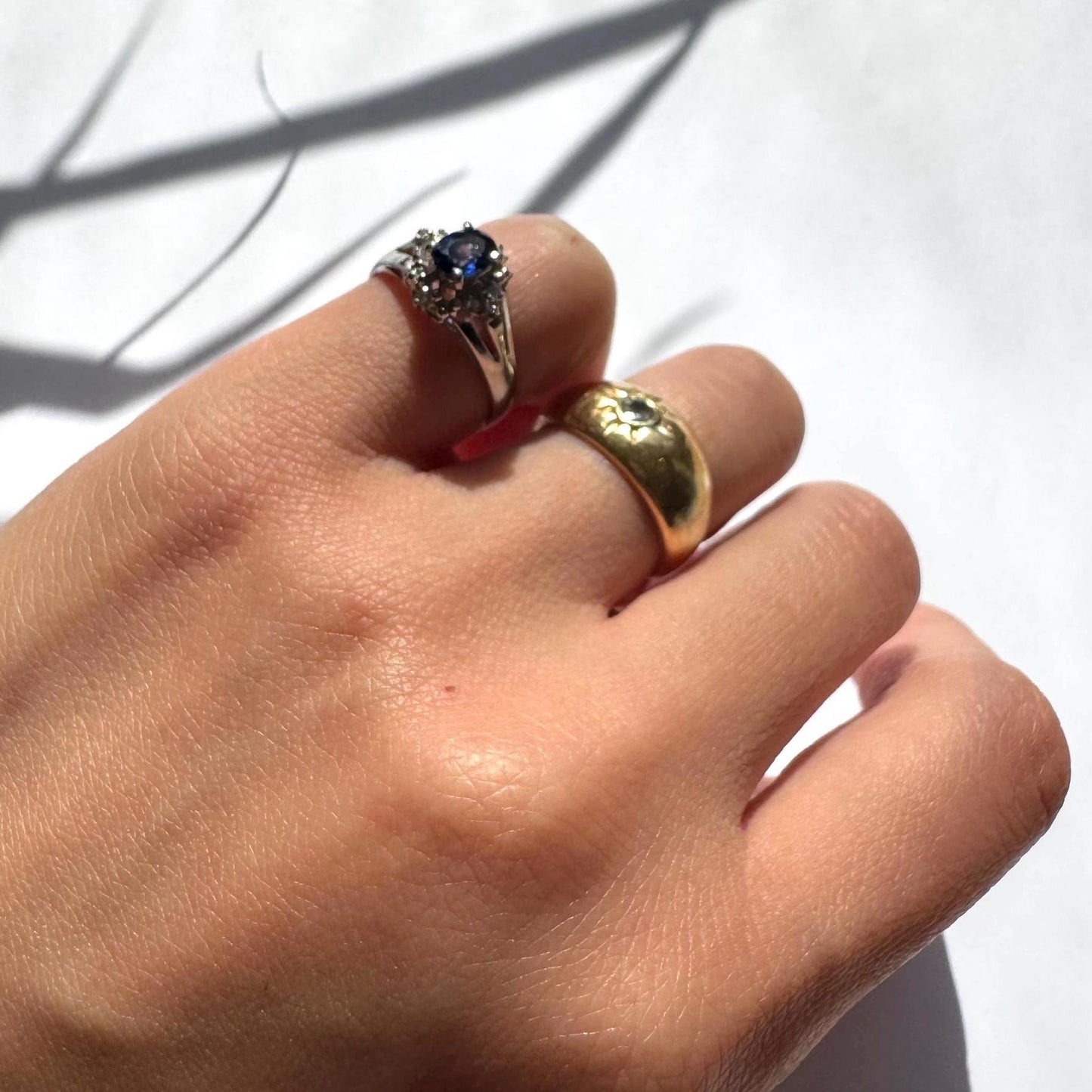 a girl wearing authentic blue sapphire ring with natural diamonds in platinum band as pinky ring with a gold band