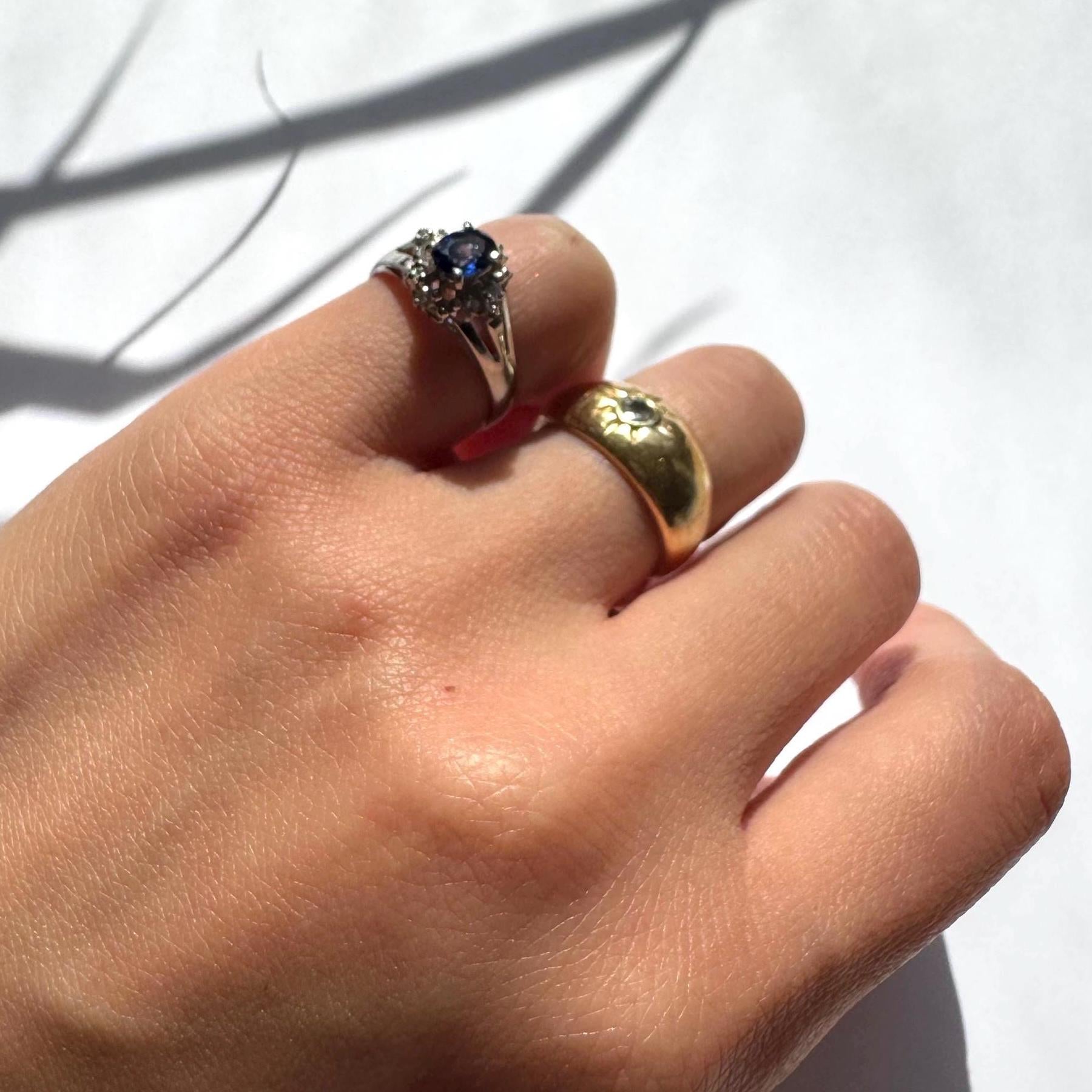 a girl wearing authentic blue sapphire ring with natural diamonds in platinum band as pinky ring with a gold band