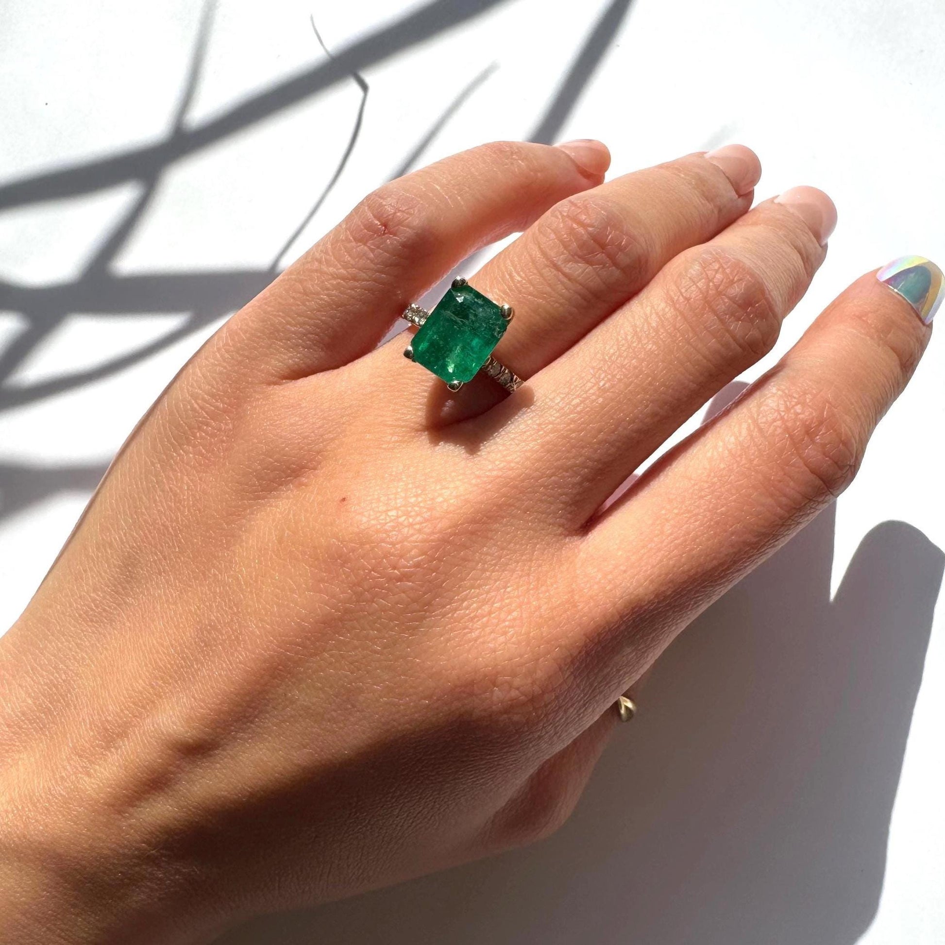 a girl wearing 14k yellow gold ring with authentic natural emerald and natural diamonds engagement ring anniversary ring