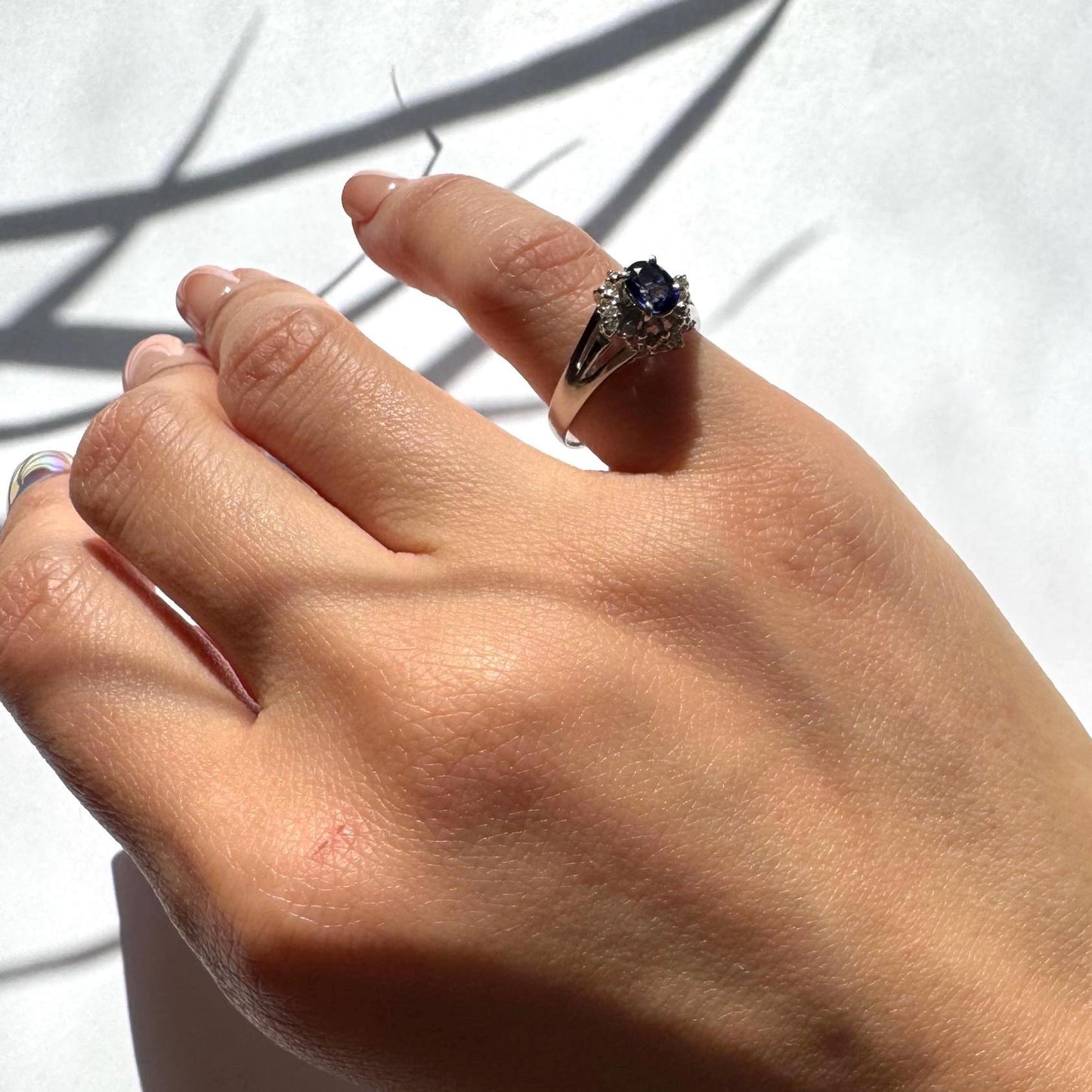 a girl wearing authentic blue sapphire ring with natural diamonds in platinum band as pinky ring