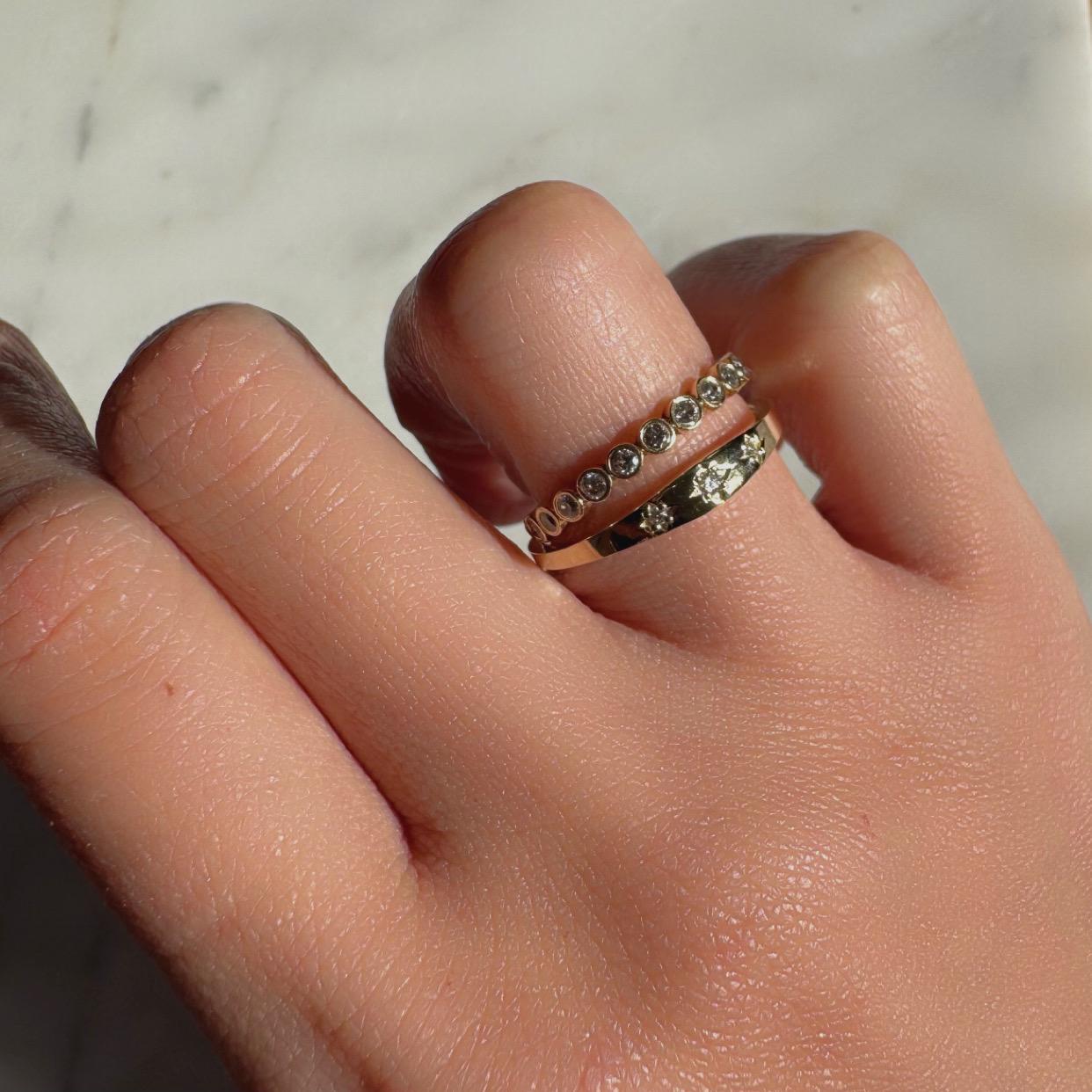a girl wearing 3 diamond gypsy style ring made with authentic diamonds and 14k solid yellow gold celestial ring layered with another ring